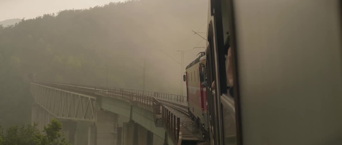 The person takes photographs from the train window