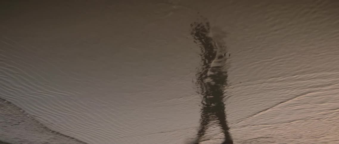 Silhouette of a woman in the reflection at the beach