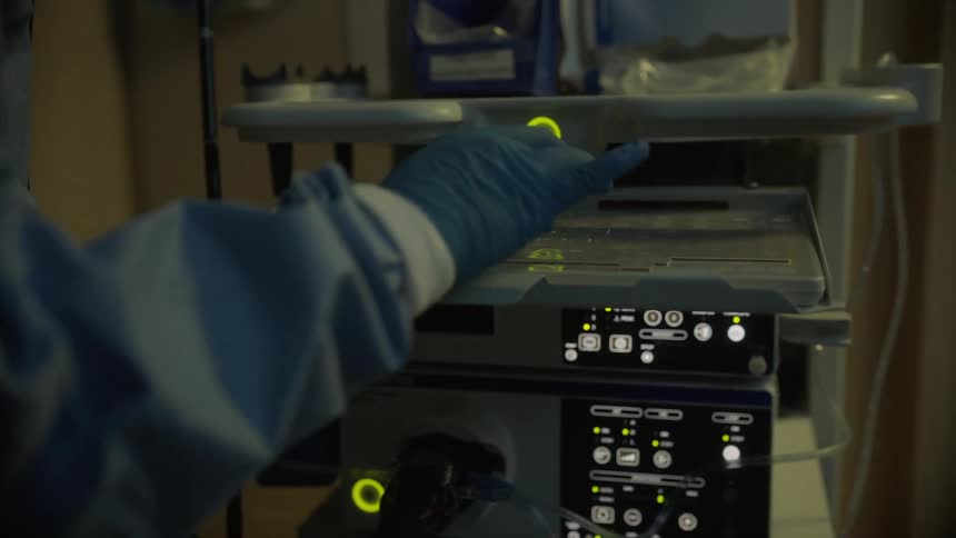 A person is typing on a keyboard on some medical equipment