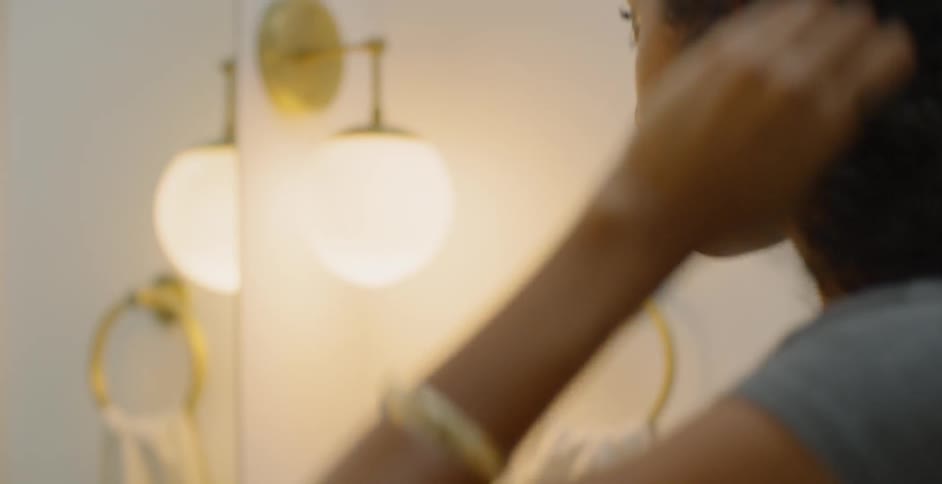 Woman applies makeup in front of a mirror and bright light