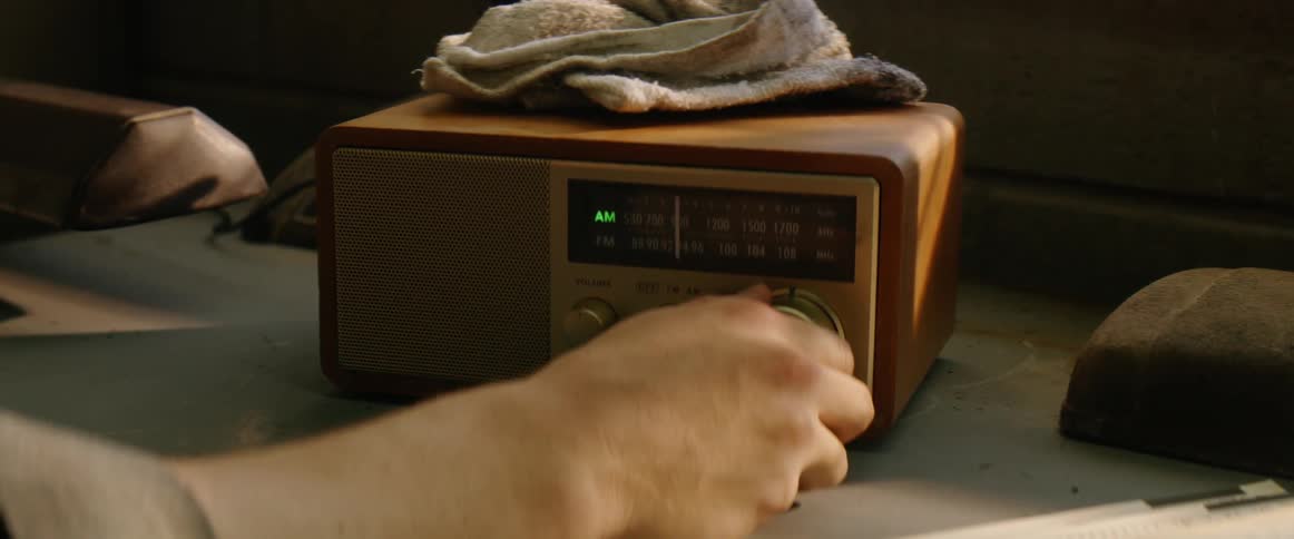 A person turns a dial on a radio