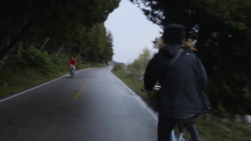 The people ride past each other on bicycles