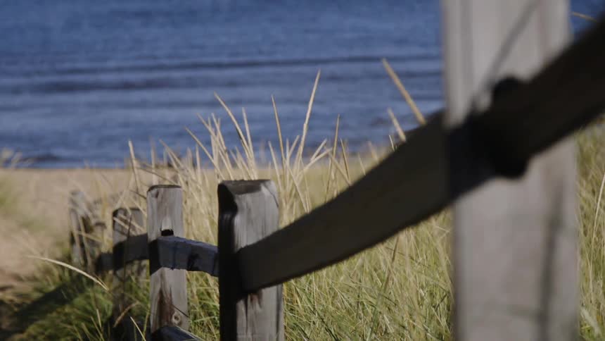 The wooden fence leads down to the beach
