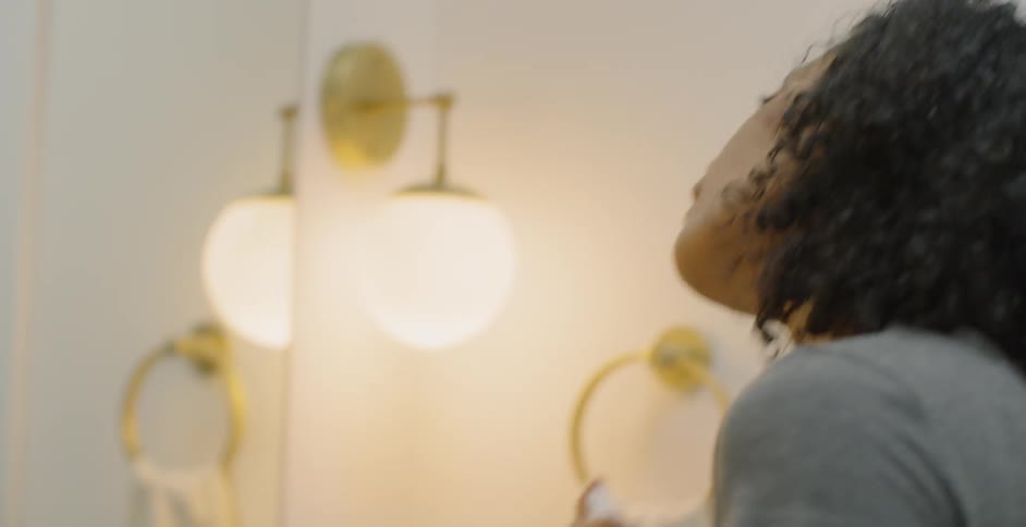 Woman in front of mirror using a mister