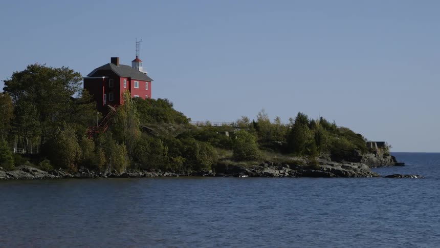 The large house is on a hill by the water