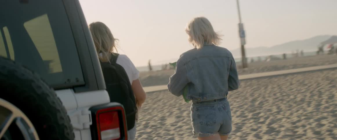 The two women walk together onto the beach from their vehicle
