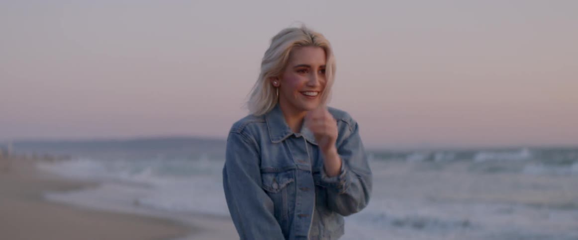 The woman laughs and spins on the beach