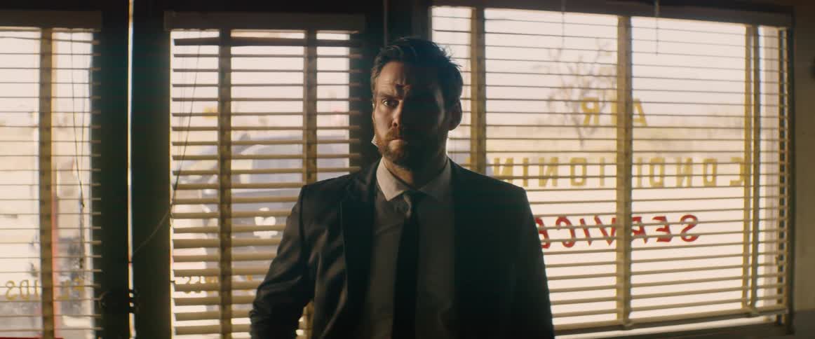 The man in a suit stands by the door
