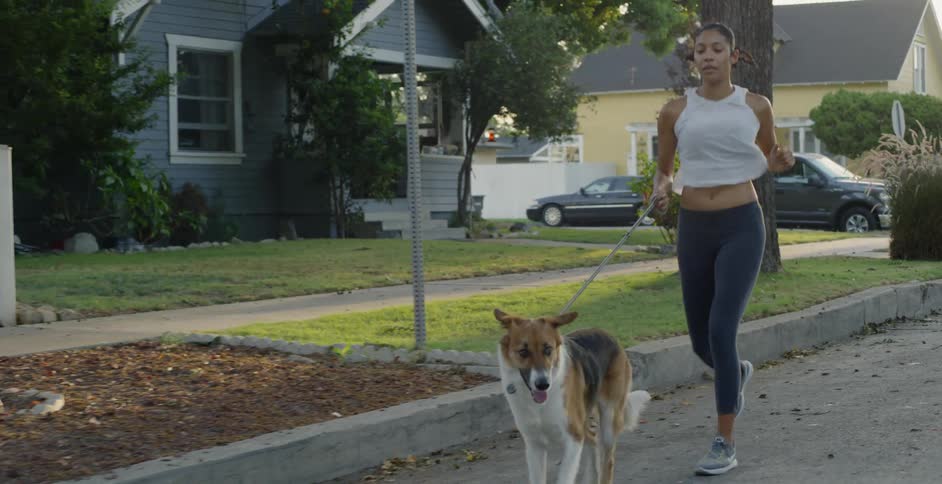 Woman runs through neighborhood with her dog