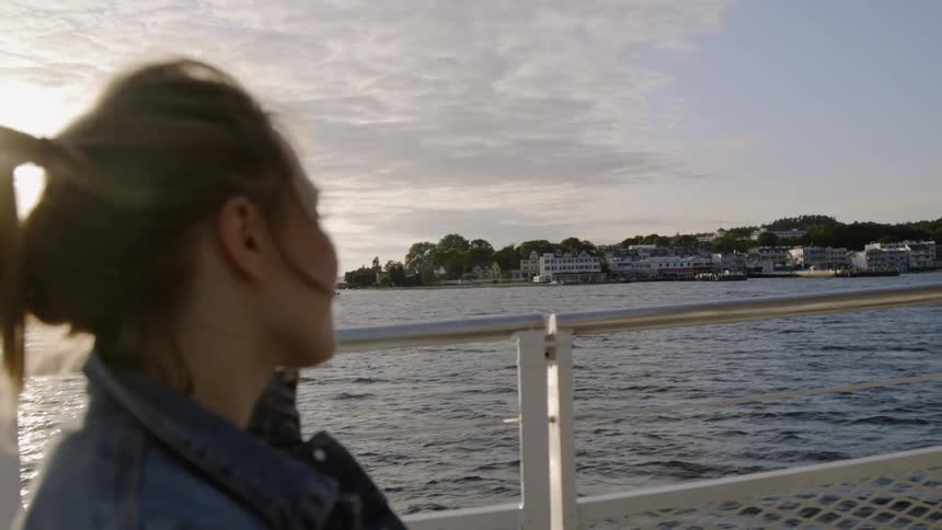 Woman sits on a boat looking out at the water