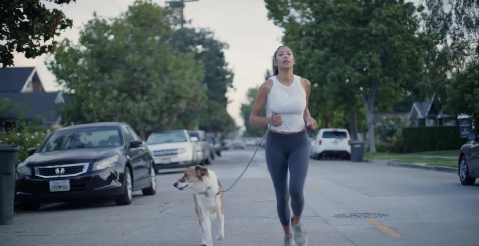 The woman jogs with her dog on a cloudy day