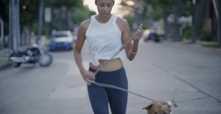 Woman runs with a dog on a city street