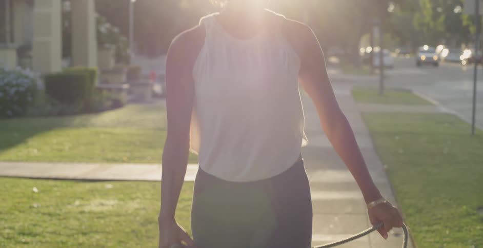 Woman walks dog along sidewalk