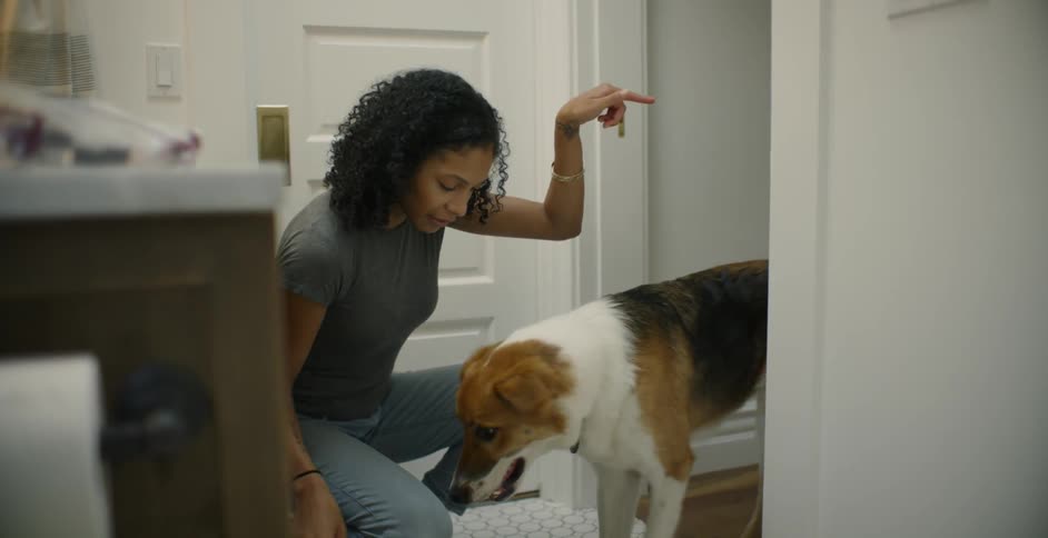 The woman turns in the bathroom to pet her dog
