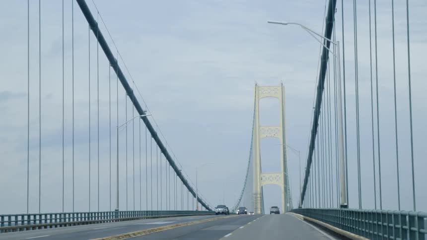The vehicles travel over the bridge