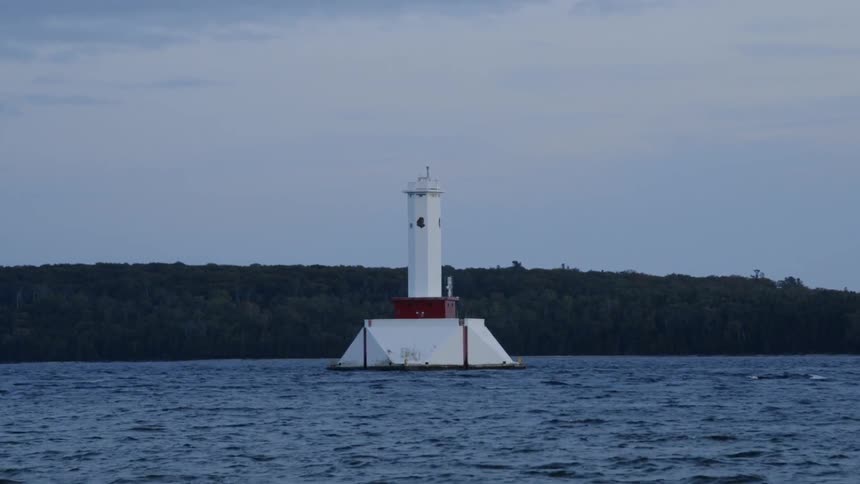 The lighthouse is by a tent floating on the water