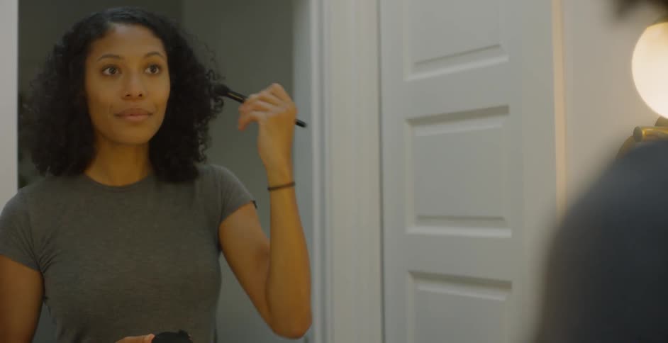The woman applies makeup to her face
