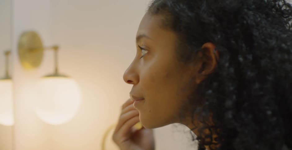 A woman uses a brush to apply makeup to her cheeks