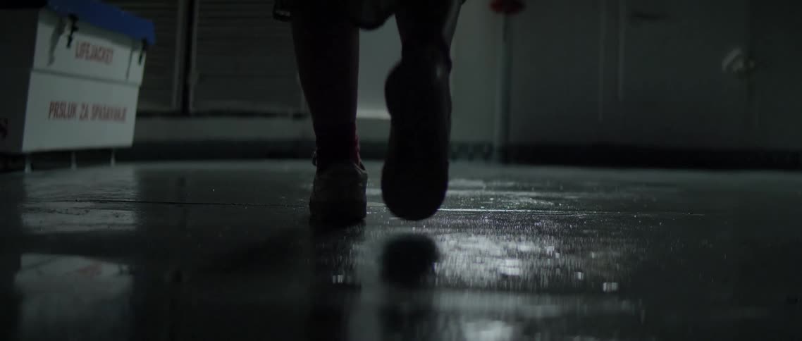 A person walks across a floor in a dark room