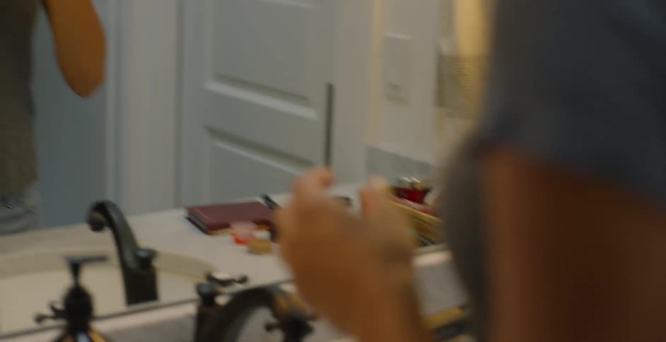 The woman is freshening up in the restroom