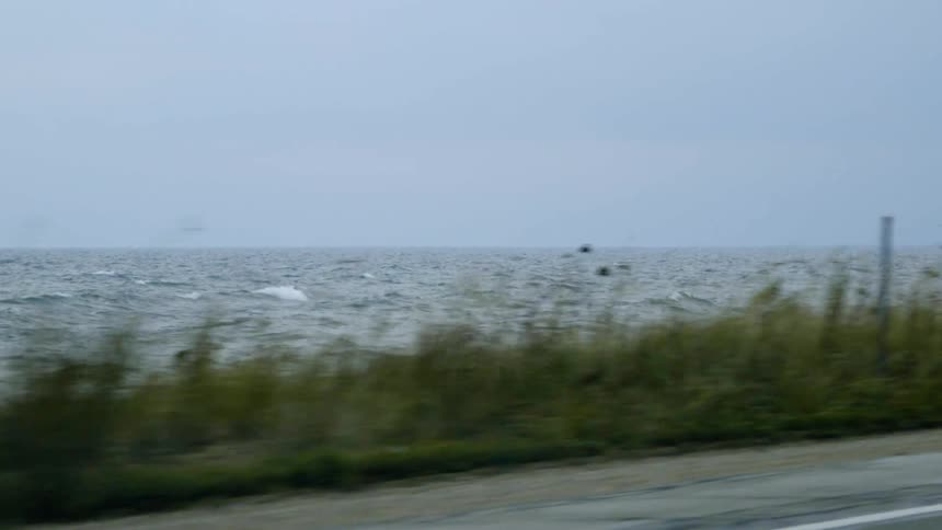 The shore near the road has very rough waters