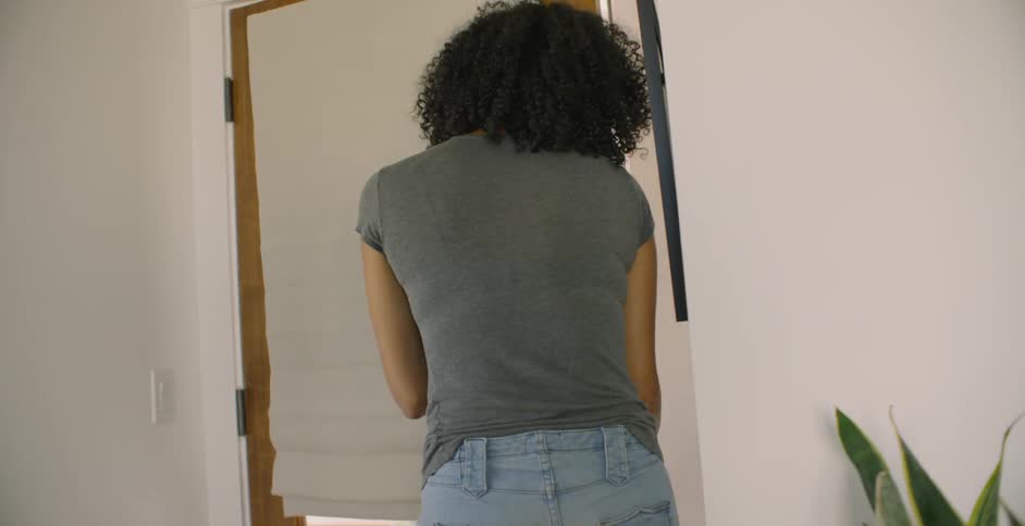 Woman opens the door carefully in front of the dog and hugs a man