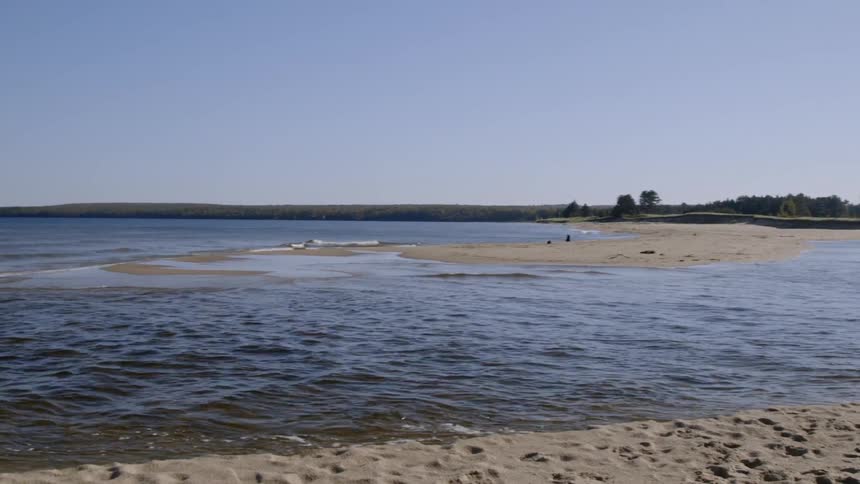 The waves slowly hit the sand of the shore