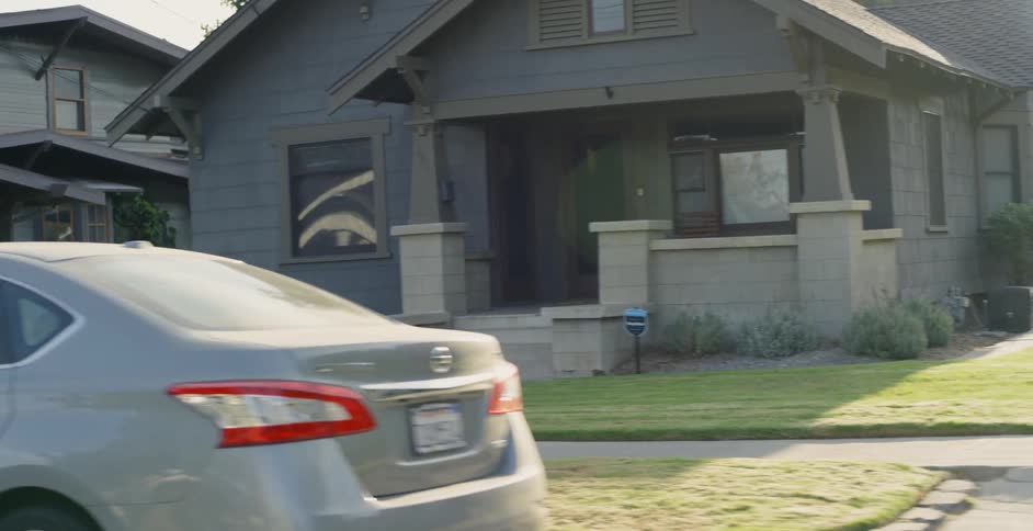 Sun shines over many houses and vehicles