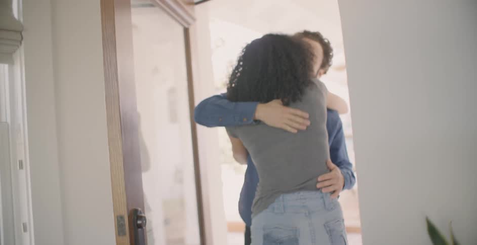 The man and woman hug at the doorway