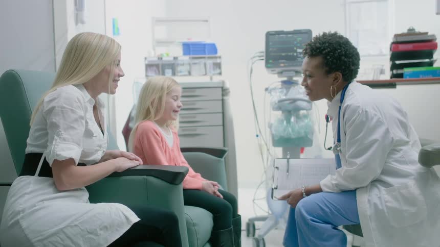 A doctor is talking to a child and her mother