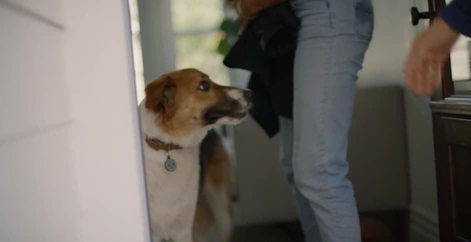 Woman grabs her coat and closes the front door as a man waits for her