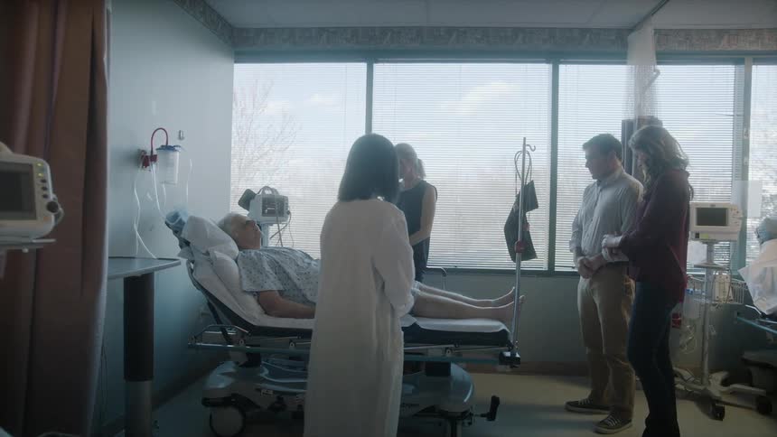 Visitors surround a hospital patient