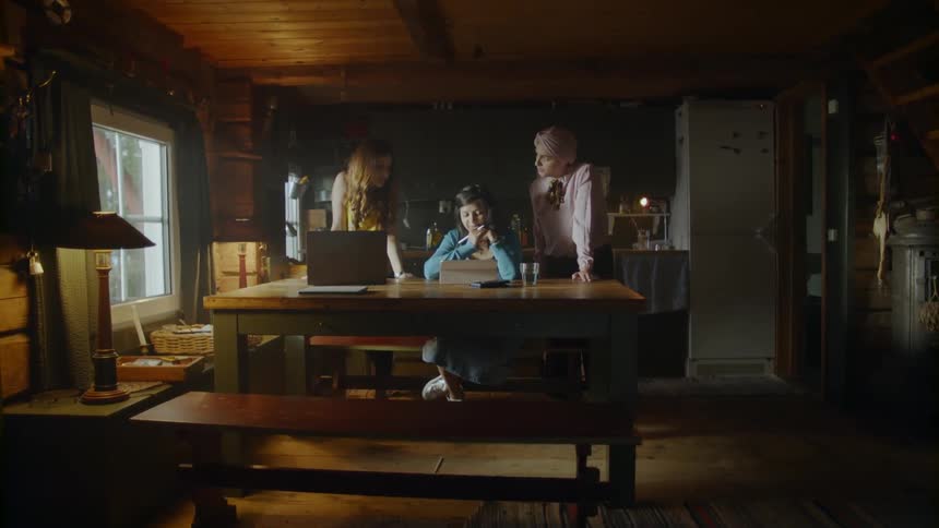 Several women sitting around the table in a cabin