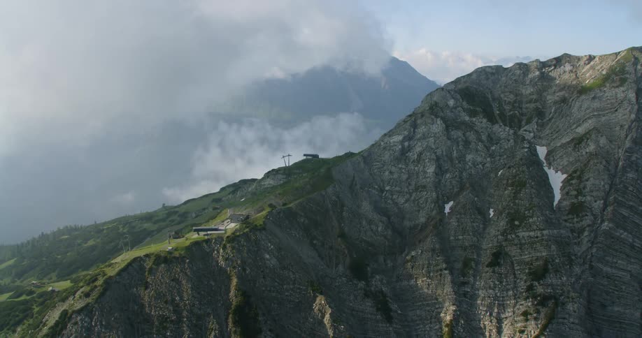 The clouds are rolling over the mountains in the distance