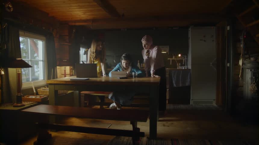 The women walk over to another sitting at the table