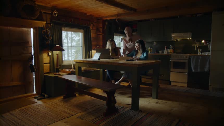 The woman walks around the dining room table