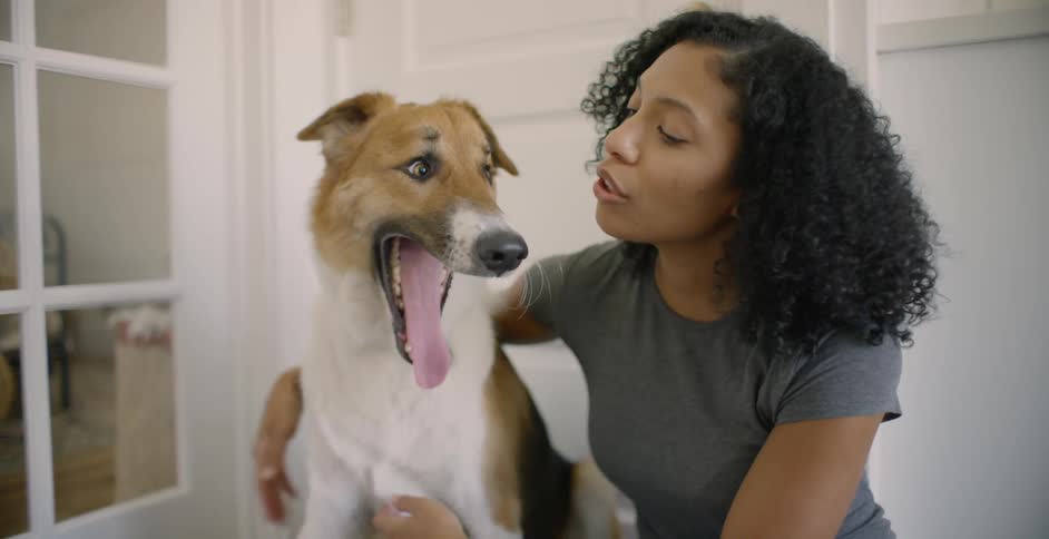 The woman hugs her dog on the mat