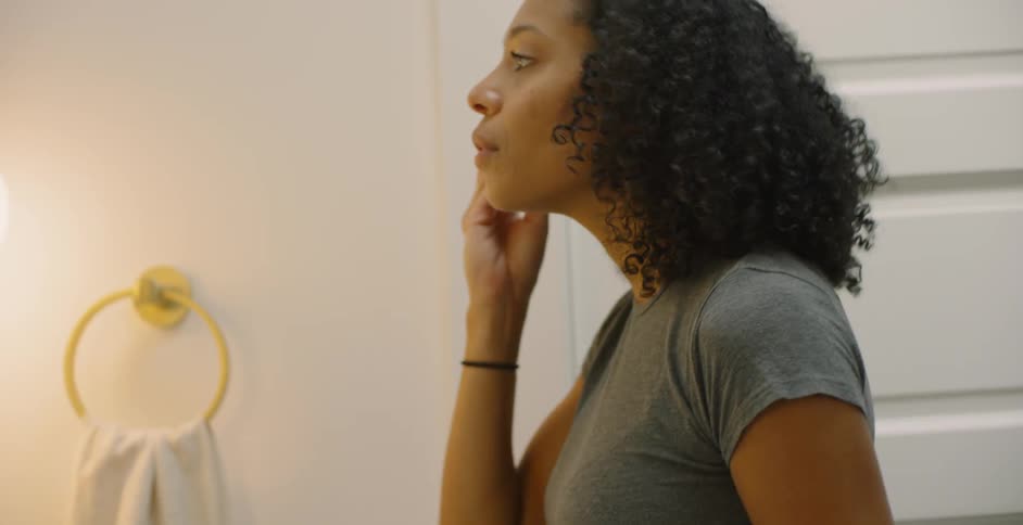 The woman uses the brush in front of a mirror