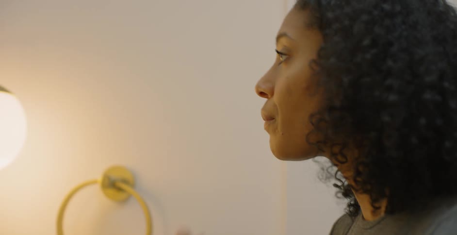 A woman applies lip balm in a bathroom