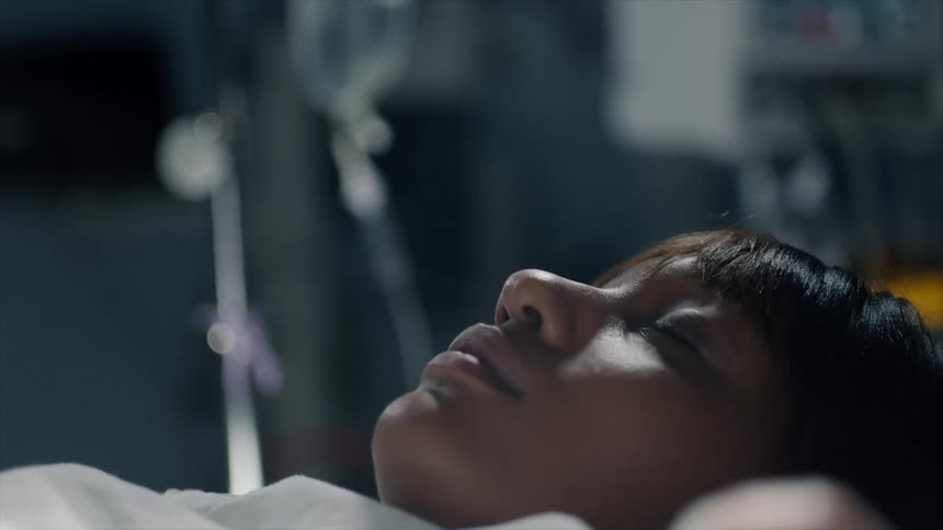 A woman sleeps on a bed in a hospital