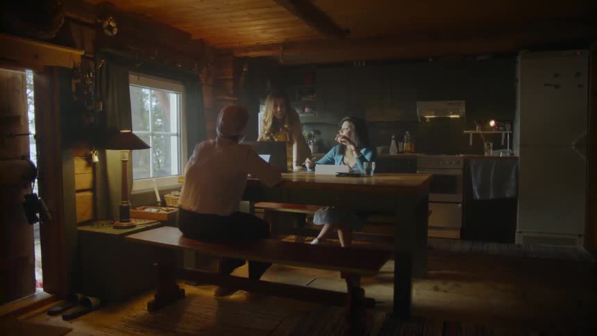 Three women talk at the dining room table with tablets