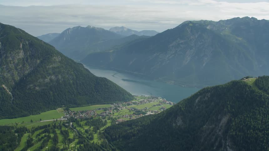 The town is sitting near the water between the mountains