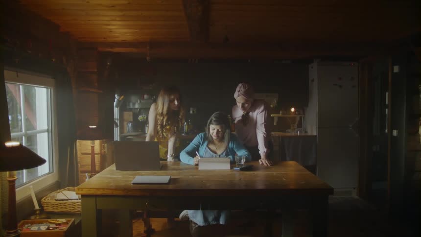 The woman talks with two others standing behind her