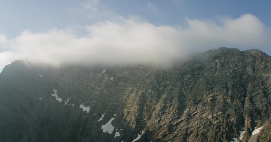 Clouds hang over a rocky ridge