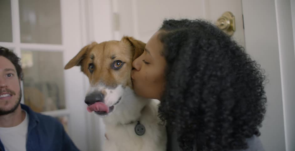 The woman kisses her dog on the cheek