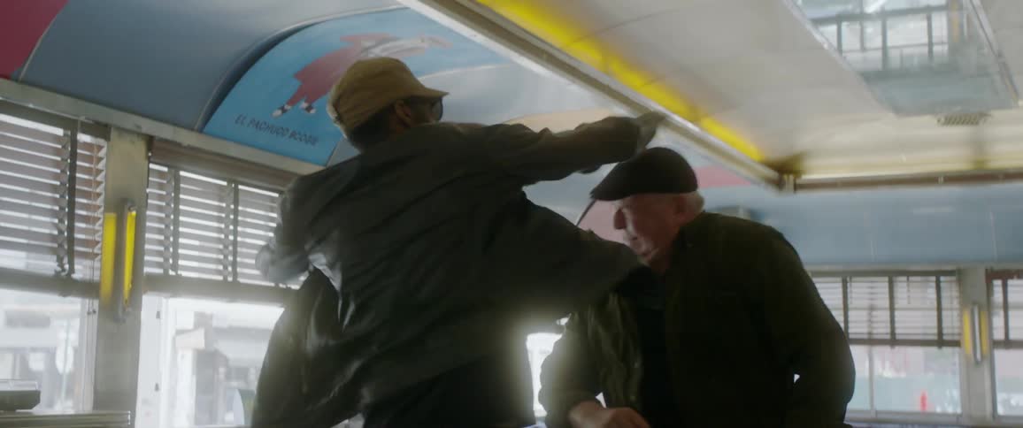 A man hits an older man sitting at a diner counter in the head