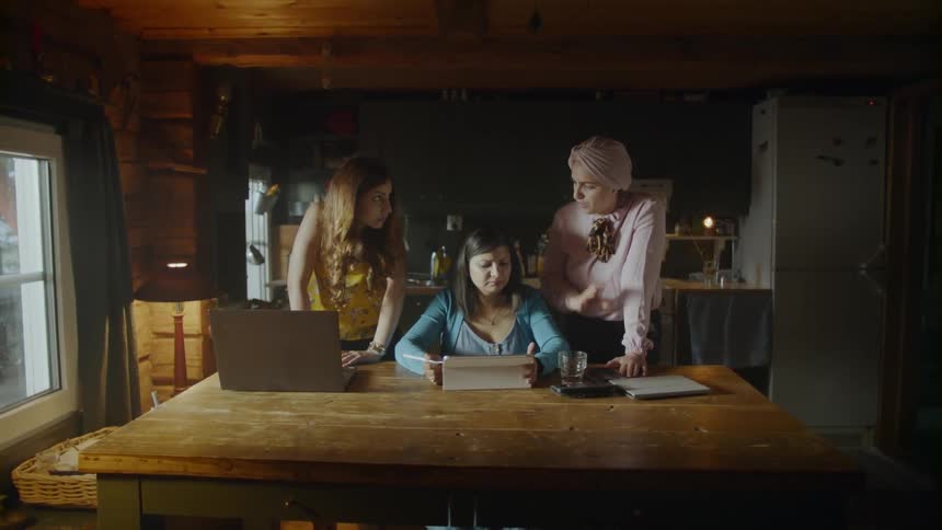 The women talk together at the dining room table