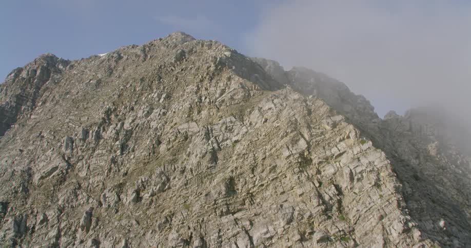 Mountains stand tall under the blue sky and white clouds