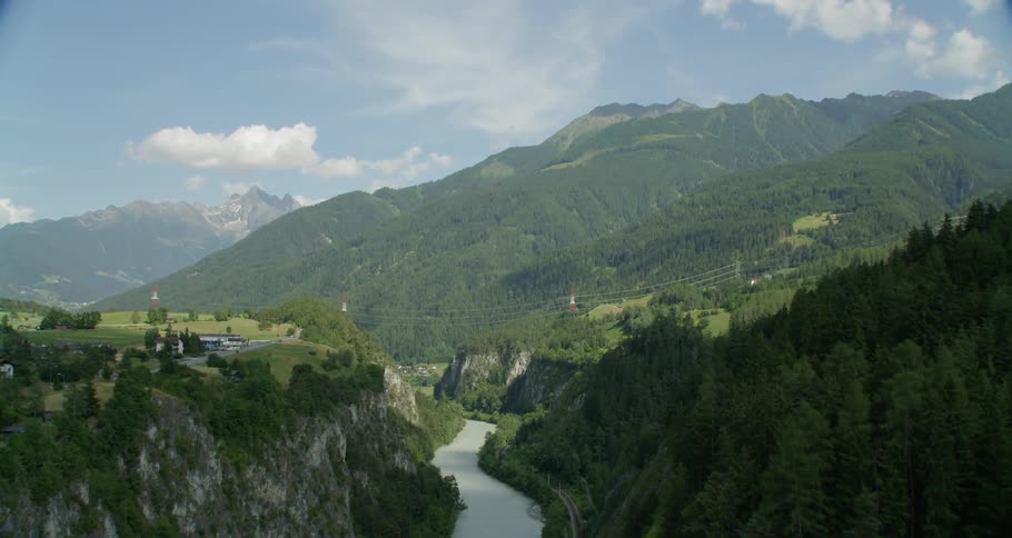 The river runs along the hills covered with trees