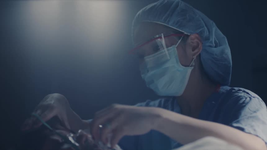 A nurse tends to an unconscious woman in an operating room